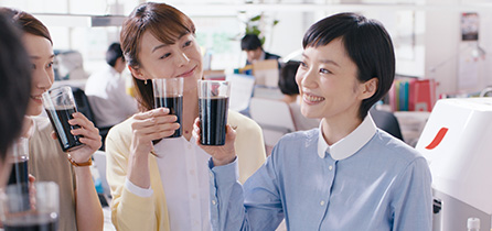 写真 職場 笑顔 みんながコーヒーを持っている